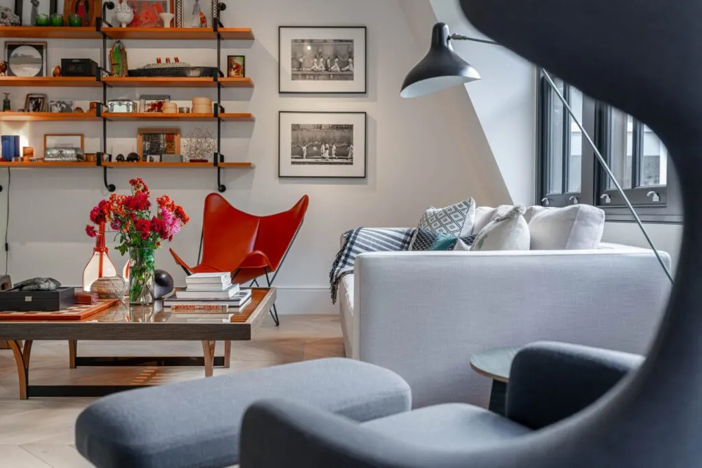 A cozy living room with a stylish couch, a comfortable chair, and elegant bookshelves. Photo at Nationwide Properties Contractors' London Westminster project